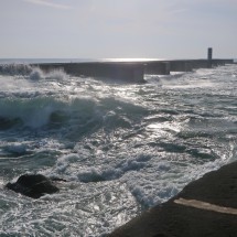 Huge waves with the lighthouse on the north side of the estuary of Rio Douro